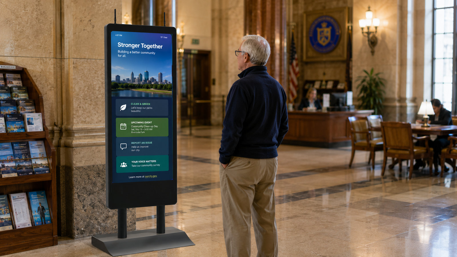 A visitor reads community programs on a HootBoard AirX kiosk in a historic city hall lobby